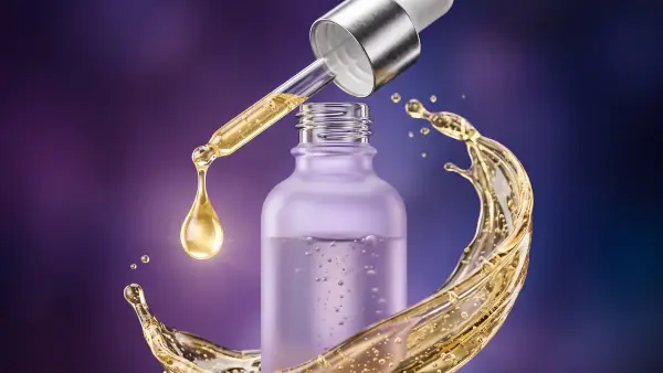 Flacon de sérum en 3D avec une goutte dorée